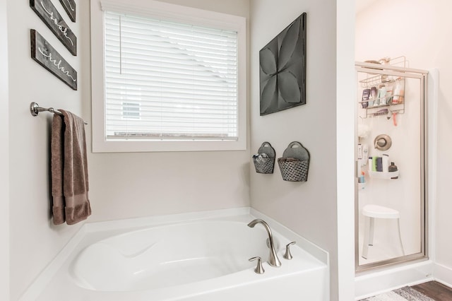 bathroom with shower with separate bathtub and hardwood / wood-style flooring