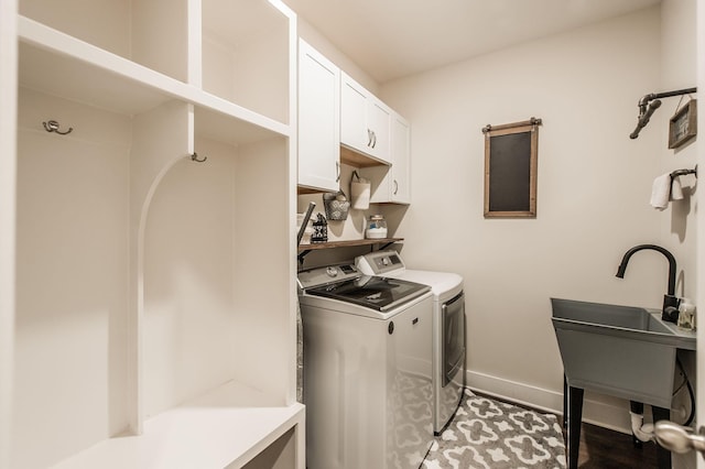 laundry room featuring cabinets, sink, and washing machine and clothes dryer