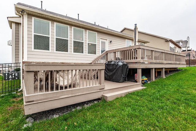 back of house featuring a deck and a yard