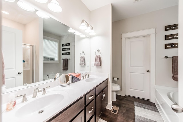 bathroom with a bathtub, vanity, wood-type flooring, and toilet