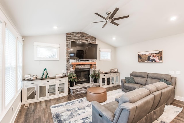 living room featuring a stone fireplace, ceiling fan, wood-type flooring, and vaulted ceiling