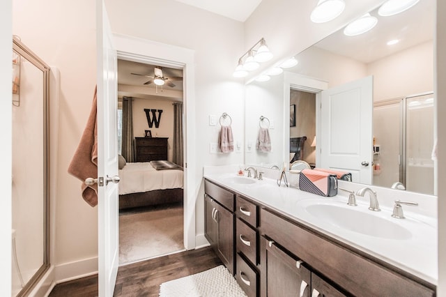 bathroom with wood-type flooring, vanity, a shower with door, and ceiling fan