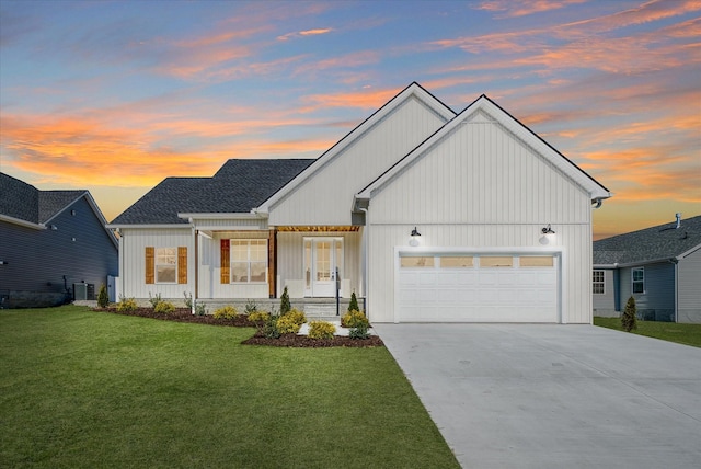 view of front of home featuring a garage, central AC, and a yard