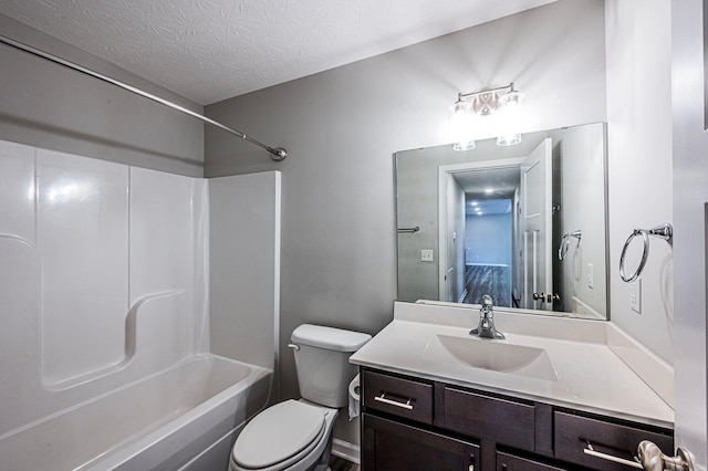 full bathroom featuring shower / bathing tub combination, vanity, toilet, and a textured ceiling