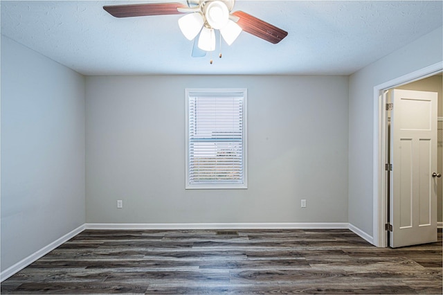 empty room with ceiling fan, dark hardwood / wood-style flooring, and a textured ceiling