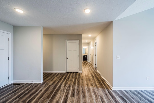 hall with dark hardwood / wood-style floors and a textured ceiling