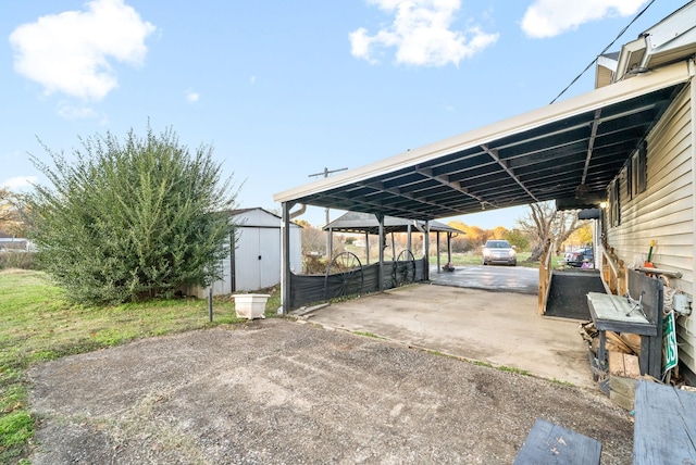 view of patio / terrace with a carport and a storage shed