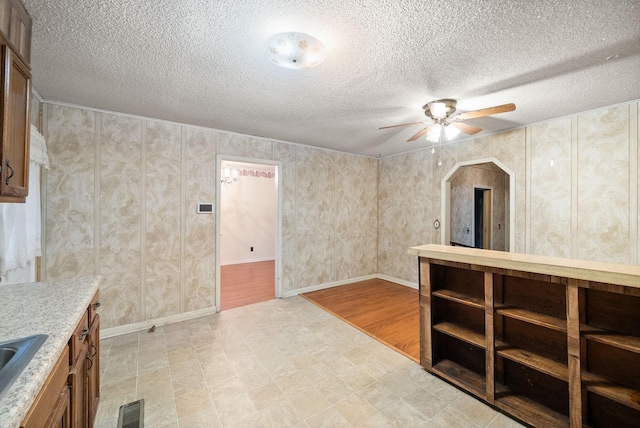 interior space featuring sink, a textured ceiling, and light hardwood / wood-style flooring