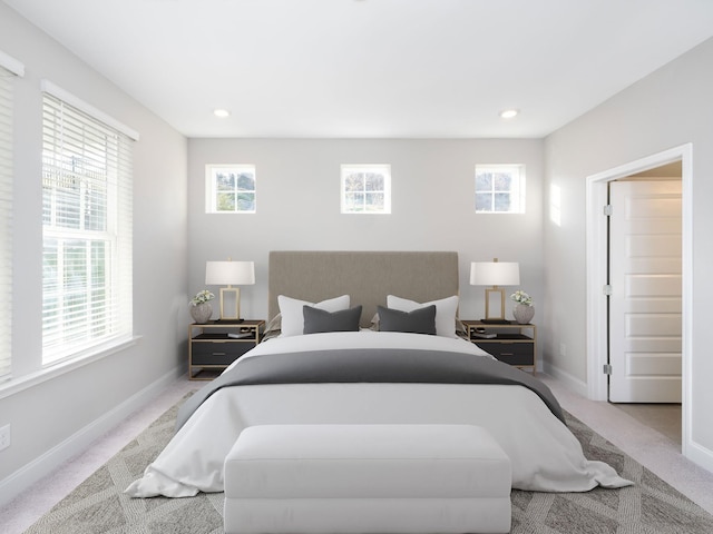 bedroom featuring light colored carpet and multiple windows