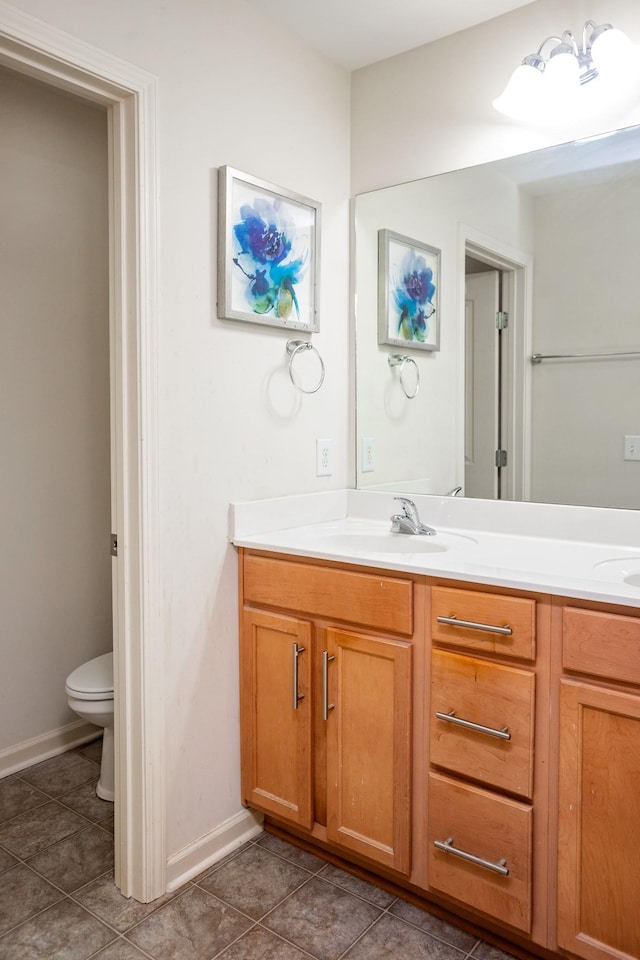 bathroom featuring tile patterned floors, vanity, and toilet