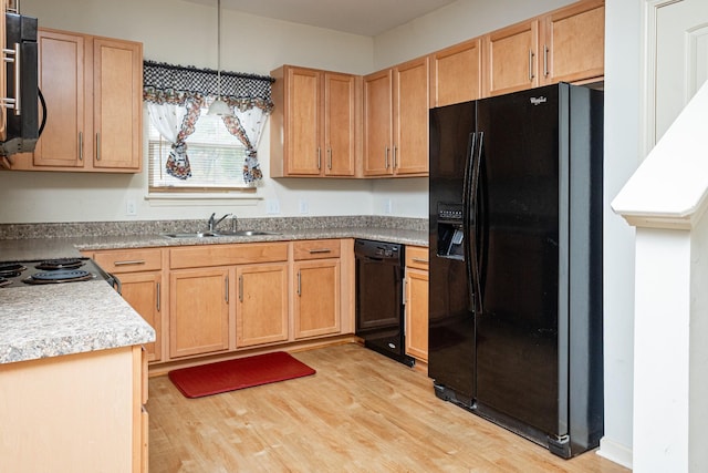 kitchen featuring sink, black appliances, decorative light fixtures, and light hardwood / wood-style floors