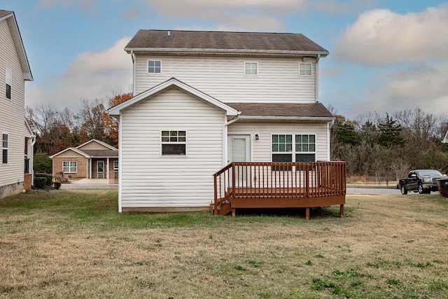 rear view of property with a wooden deck and a yard