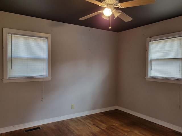 unfurnished room with ceiling fan and dark wood-type flooring