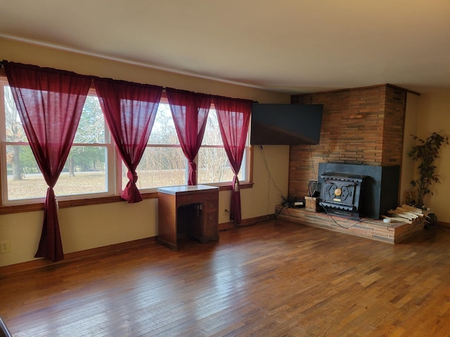 unfurnished living room featuring hardwood / wood-style floors and a wood stove