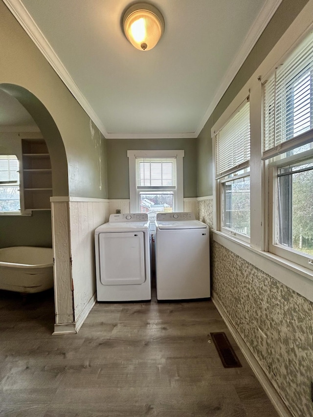 laundry area featuring hardwood / wood-style floors, washer and dryer, and ornamental molding