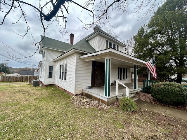 view of front of house featuring a porch, central AC unit, and a front lawn