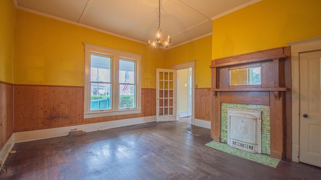 unfurnished living room featuring a notable chandelier, wood-type flooring, and ornamental molding