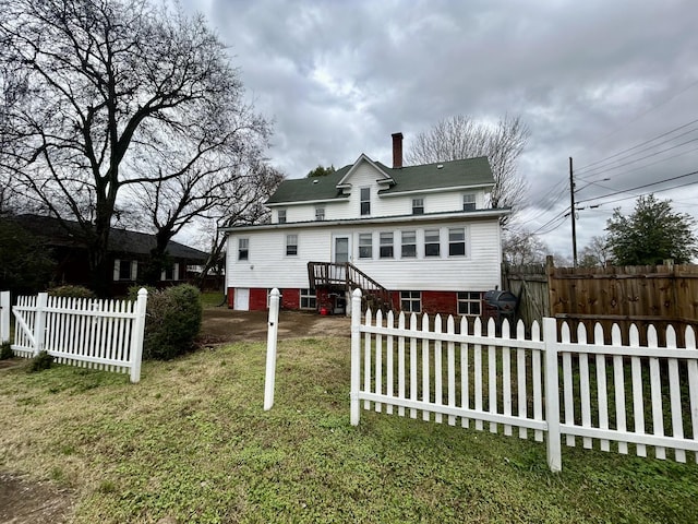 rear view of house featuring a yard