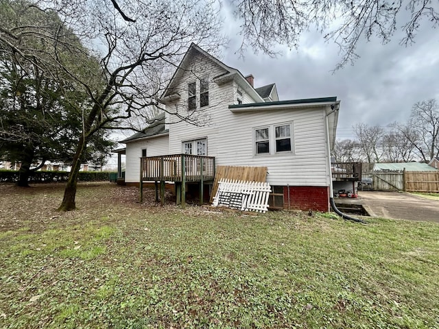 back of house featuring a wooden deck and a yard