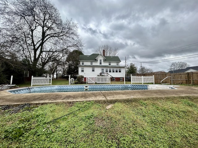 view of pool with a wooden deck and a lawn