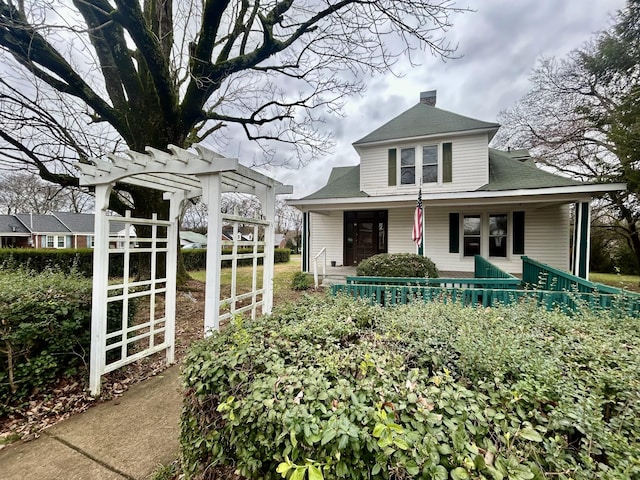 view of front of home with covered porch and a pergola