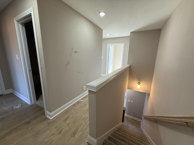 staircase with recessed lighting, wood finished floors, and baseboards