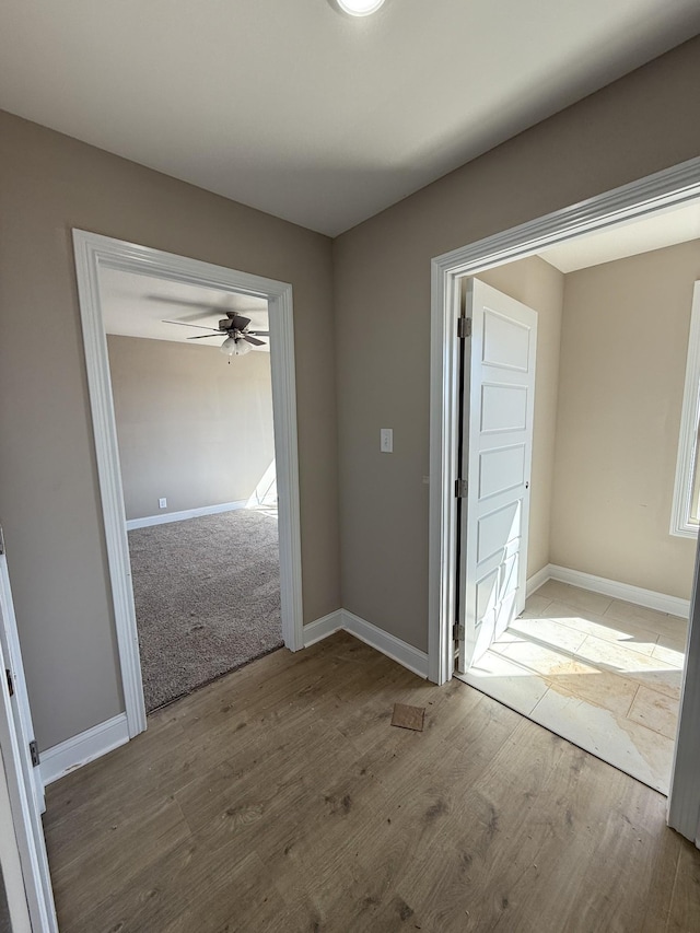 hall featuring wood finished floors and baseboards