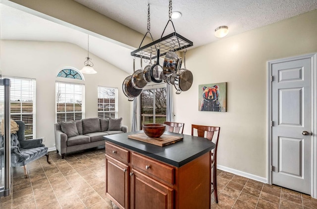 kitchen with lofted ceiling, a kitchen breakfast bar, hanging light fixtures, a textured ceiling, and a kitchen island