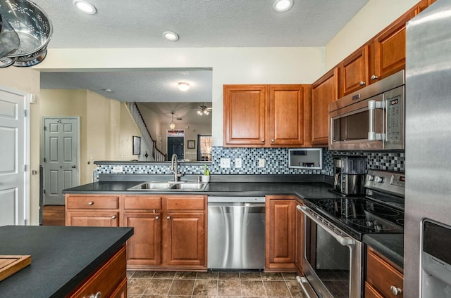 kitchen with tasteful backsplash, sink, stainless steel appliances, and a textured ceiling