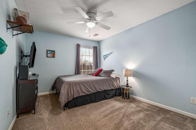 bedroom with ceiling fan, carpet floors, and a textured ceiling