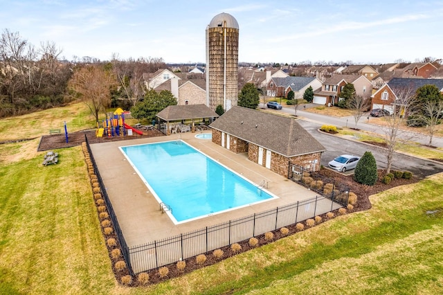 view of swimming pool featuring a playground, a patio area, and a lawn