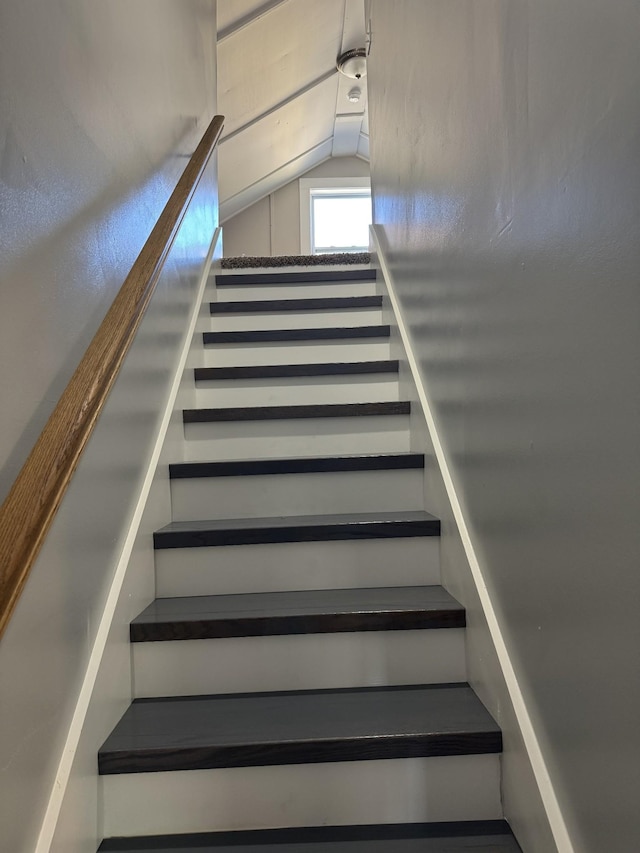 stairway featuring lofted ceiling