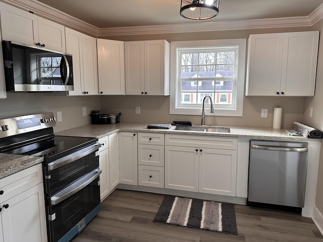 kitchen featuring white cabinets, sink, dark hardwood / wood-style floors, ornamental molding, and appliances with stainless steel finishes