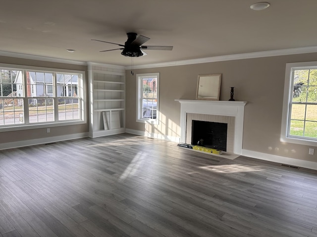 unfurnished living room with ceiling fan, wood-type flooring, a fireplace, and ornamental molding