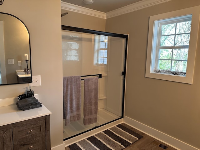 bathroom with a shower with door, vanity, hardwood / wood-style floors, and ornamental molding