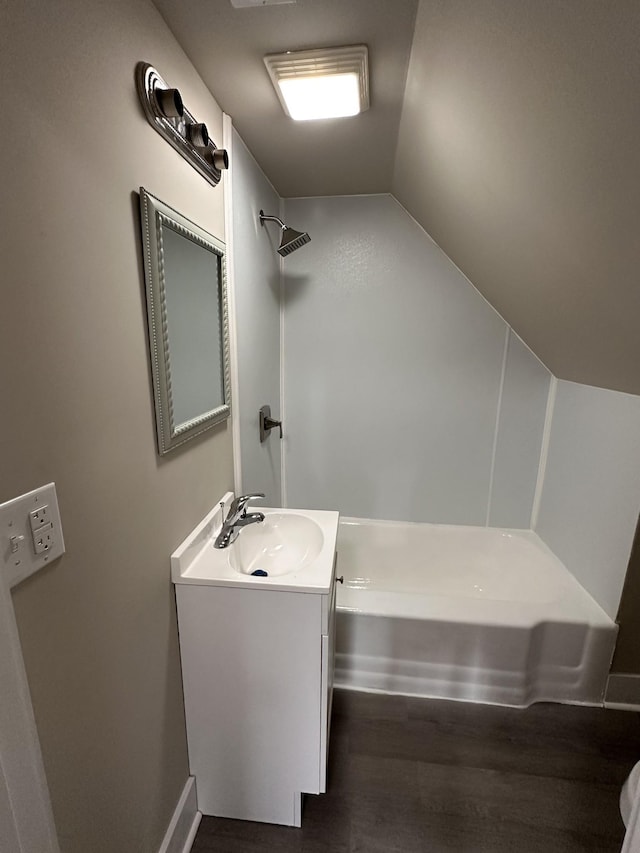 bathroom with hardwood / wood-style floors, vanity, and lofted ceiling