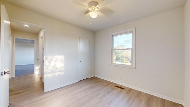 unfurnished bedroom featuring a closet, light hardwood / wood-style flooring, and ceiling fan