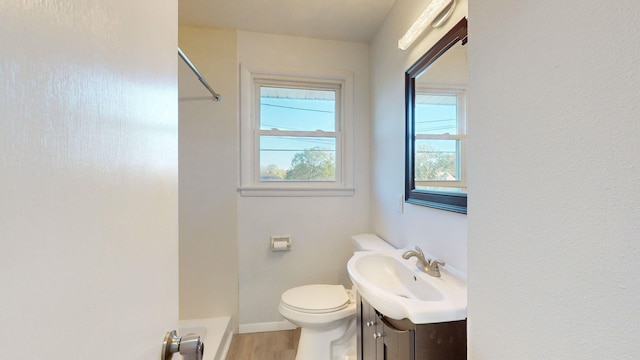 bathroom featuring a shower, hardwood / wood-style floors, vanity, and toilet