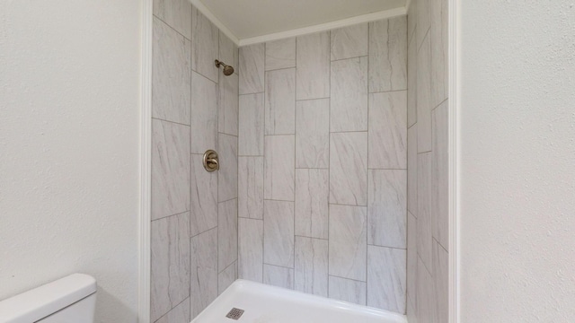 bathroom featuring toilet and a tile shower