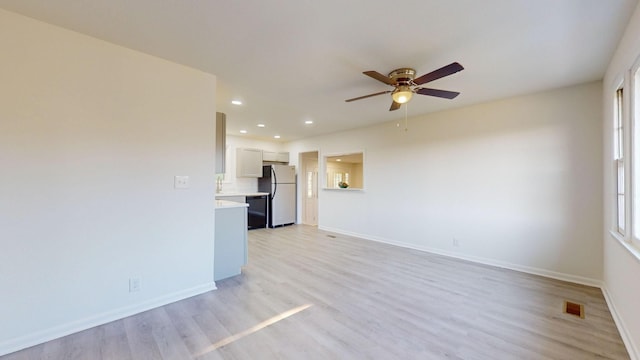 unfurnished living room featuring light hardwood / wood-style flooring and ceiling fan