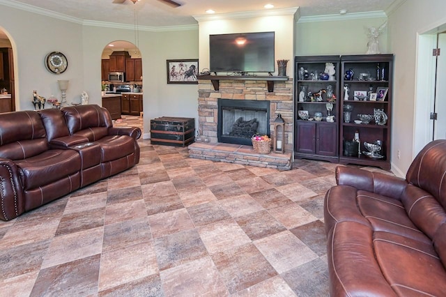 living room with crown molding, a fireplace, and ceiling fan