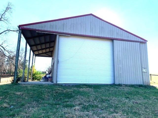 view of side of home featuring a yard and an outdoor structure