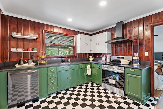 kitchen featuring sink, wall chimney exhaust hood, wood walls, appliances with stainless steel finishes, and ornamental molding