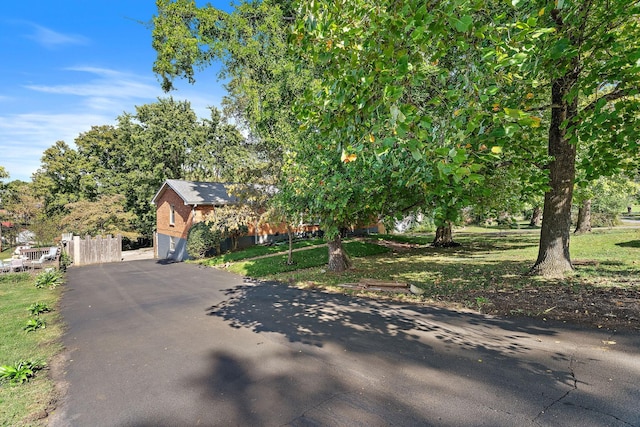 view of property hidden behind natural elements featuring a garage