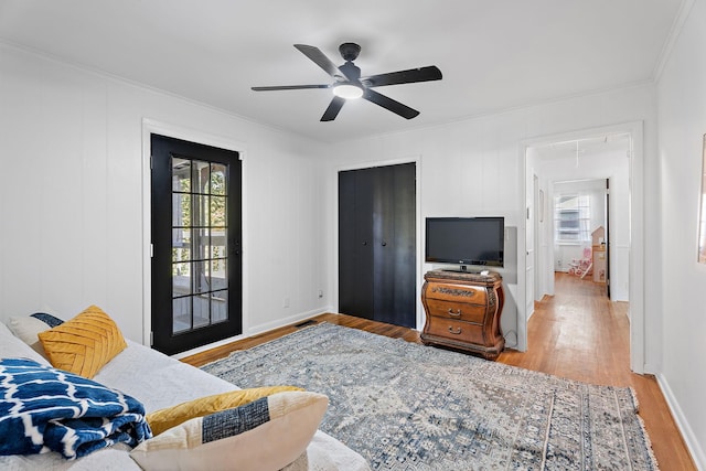 bedroom with ceiling fan, crown molding, and light wood-type flooring