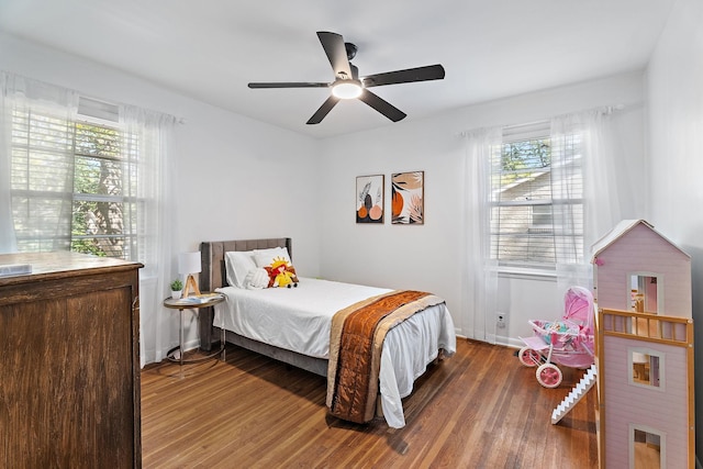 bedroom featuring hardwood / wood-style flooring, multiple windows, and ceiling fan