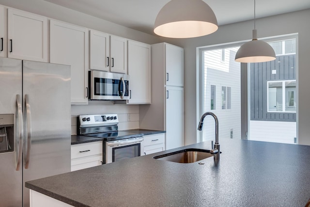 kitchen with pendant lighting, sink, white cabinetry, and stainless steel appliances