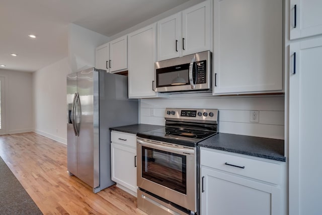 kitchen with white cabinets, light wood-type flooring, and stainless steel appliances