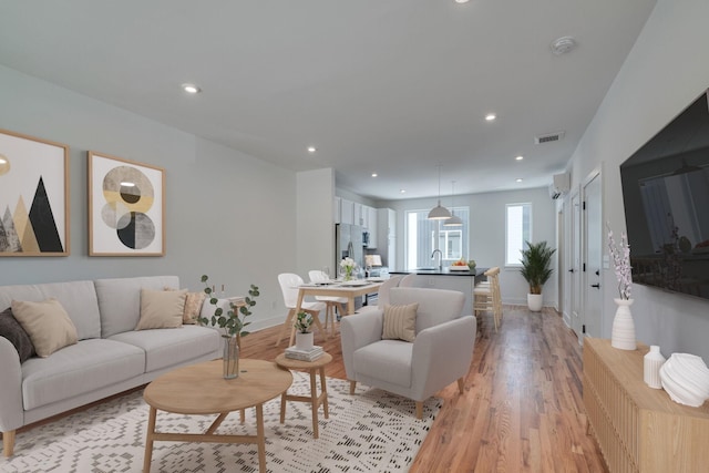 living room featuring light wood-type flooring and sink