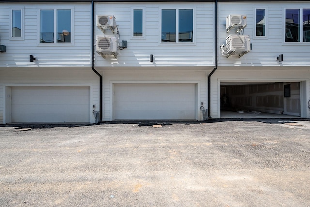 view of front of home featuring a wall mounted AC and a garage